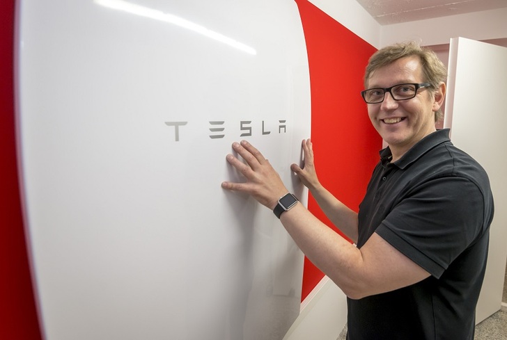 Alexander Maier in front of his Tesla battery. The architect is already planning the expand his energy storage capacity and his solar installation. - © Panasonic/Heike Rost
