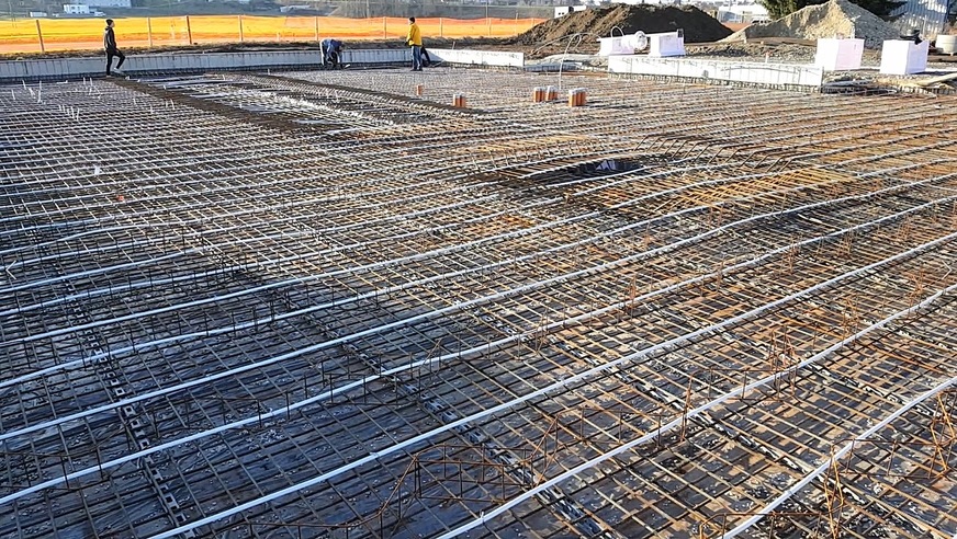 Laying of the electric heating wires before they are cast in the concrete which will form the foundation of the building and will then be used to store the surplus PV energy in the form of heat.