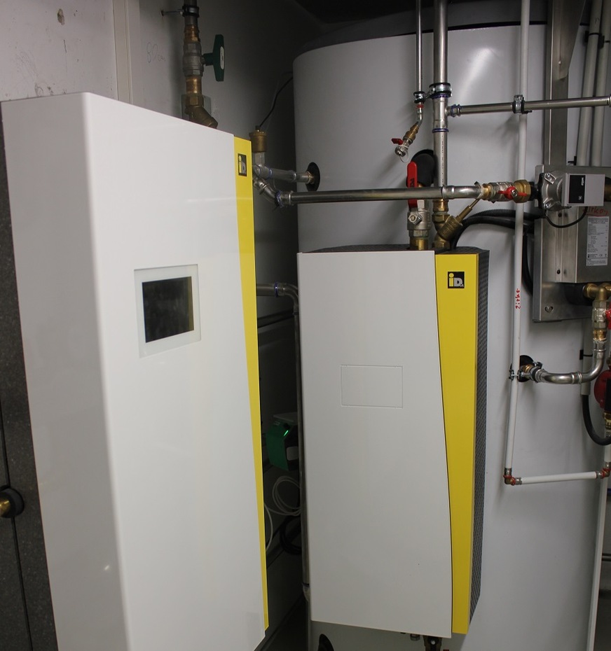 Air source heat pump with 12 kW output and heat storage tank.