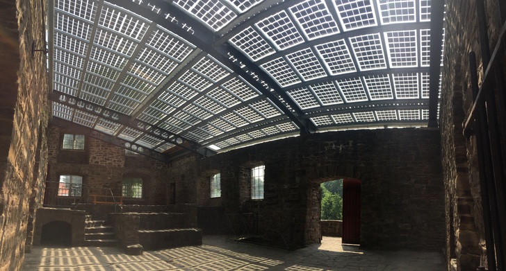 134 elegant modules were installed on the ruined manor house of the listed Wülmersen moated castle. The large-scale use of the modules creates unique lighting effects. 25,000 kWh/a are generated annually. - © Aleo Solar