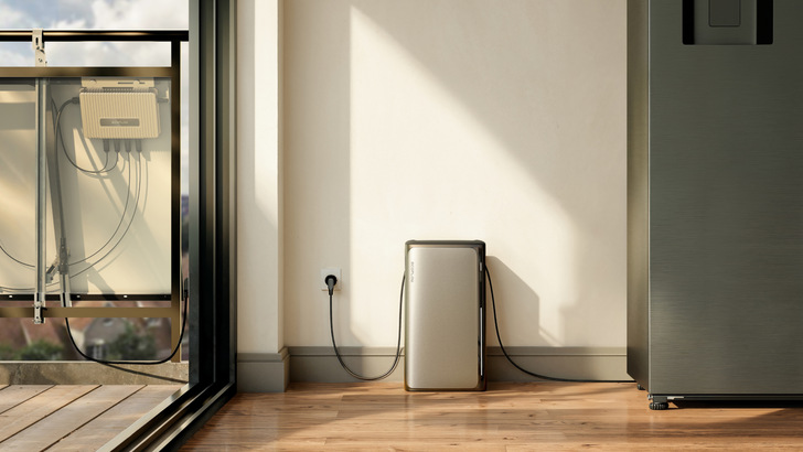 A sleek battery unit plugged into a wall outlet, near a sliding glass door and a balcony with solar equipment. - © EcoFlow A sleek battery unit plugged into a wall outlet, near a sliding glass door and a balcony with solar equipment. - © EcoFlow