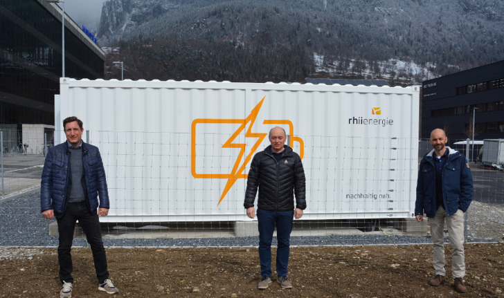 From left to right: Michel Maiorano (Axpo), Christian Capaul and Stefan Moser (both Rhiienergie) in front of the 1.25-megawatt storage unit from ADS-Tec Energy.