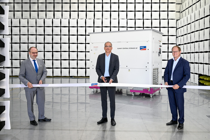 SMA CEO Jürgen Reinert (right), SMA Finance Director Ulrich Hadding (left) and the state of Hesse's Minister of Economics Tarek Al-Wazir open the new SMA test centre for electromagnetic compatibility.