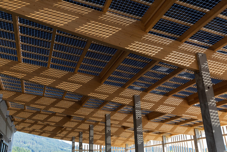 The roof construction is built of wood and covered with semi-transparent, bicafial solar modules.