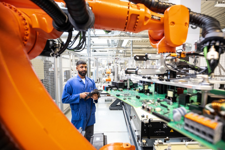 Sinan Sayilgan is controlling the robot, which has recently been deployed in SMA's electronics production.