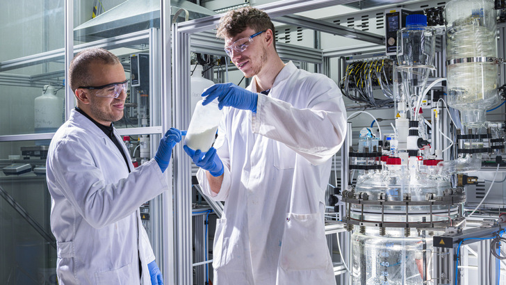 Litona founder Sebastian Büchele shows a bottle of the energy storage material Prussian white for sodium-ion batteries. - © KIT, Markus Breig
