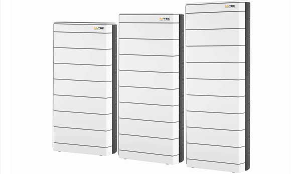 Three tall, white, rectangular battery storage units with black edges, standing side by side. - © M-Tec