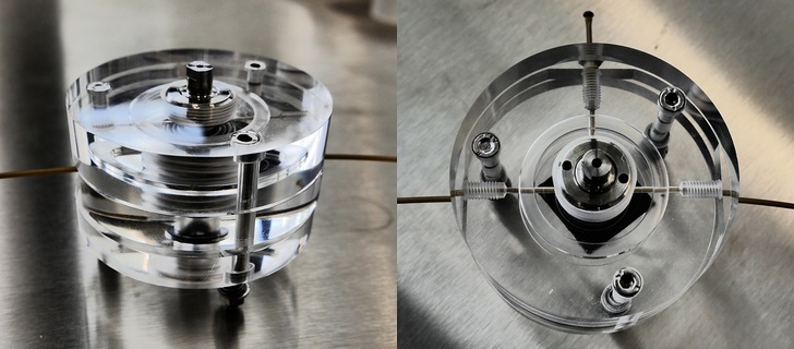 Test set-up for the silicon battery: the battery itself is only the size of a button cell and is located in the hollow cylinder in the middle of the acrylic glass casing. The thin channels that pass through the housing control the supply and outlet of the electrolyte fluid. - © Institute of Energy and Climate Research (IEK)
