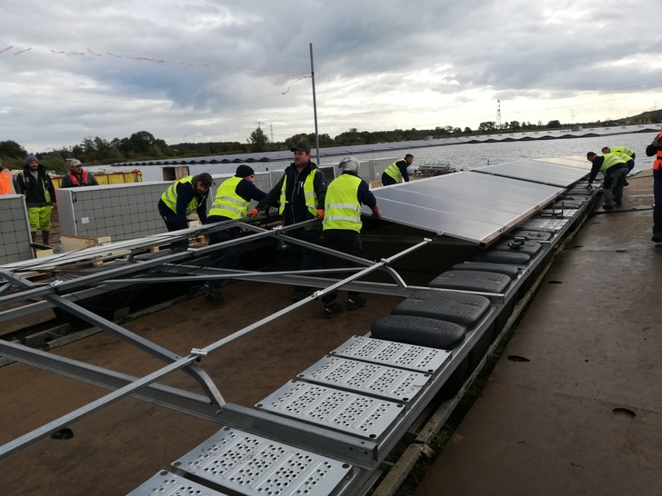 A Romanian construction team is finishing one of the "solar boats" of the floating PV System near Zwolle. - © H.C. Neidlein
