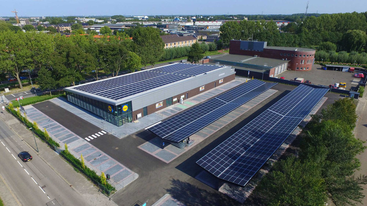 The project includes this large solar carport and a DC fast charging point for EVs. - © BayWa r.e.
