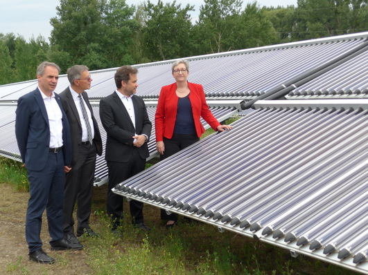 Carsten Körnig (BSW), Burkhard Exner (City of Potsdam), Moritz Ritter (Ritter Energie- und Umwelttechnik) and Federal Minister for Building Klara Geywitz (SDP) in front of the solar thermal ground-mounted system in Potsdam.