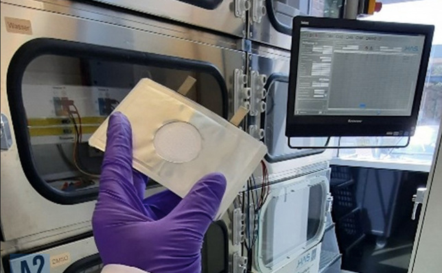 An innovative lithium-air battery cell in front of a test stand.