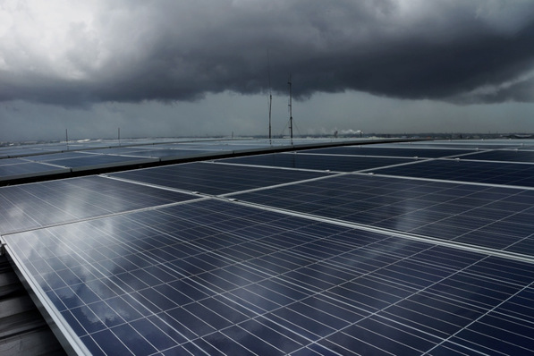 Solar PV rooftop under a storm cloud.