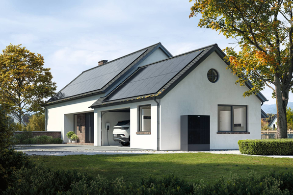 Modern white house with solar panels, a car in the garage, surrounded by trees and grass. - © Viessmann
