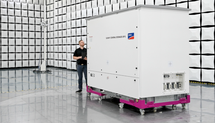 A person moves a large electrical device on wheels in an industrial testing facility. - © SMA
