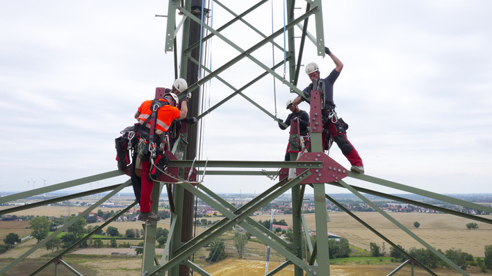 Not a moment to be taking in the view – overhead line fitters replace an electricity pylon 80 metres up.