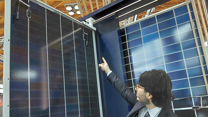 Gianluca Michieletto indicates the repositioned junction boxes on the back of the JA Solar Deep Blue module in Rimini