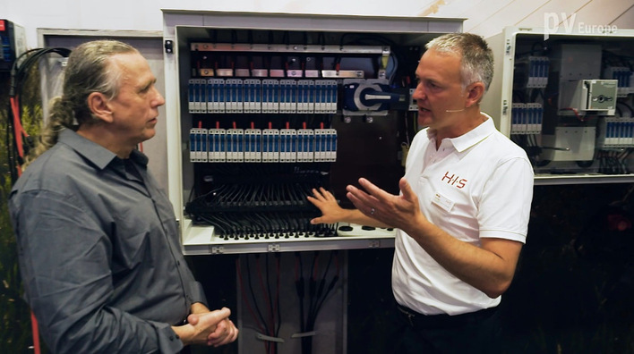 Oliver Glenz (right) explains intelligent combiner boxes including insulation monitoring on string level