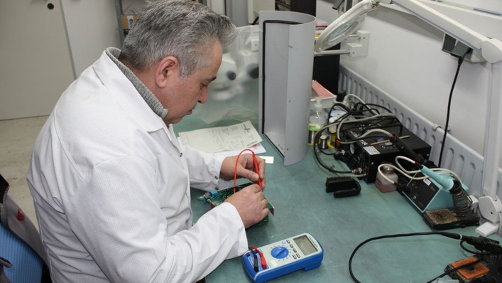 A staff member of SolarInvert repairs the control electronics of an inverter.