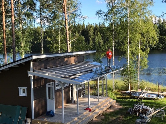 Mikko Jokinen, Category Manager, Commerce, at Onninen, tests the strength of Solarwatt panels on a new veranda with his more than 100kg frame. 